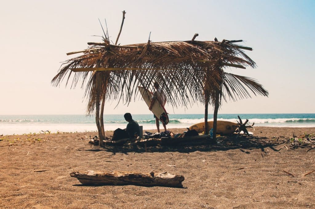 Men watching surf under shelter on the beach