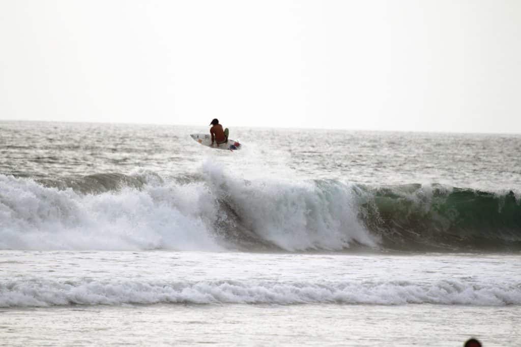 Surfer punting at a beach near Tamarindo