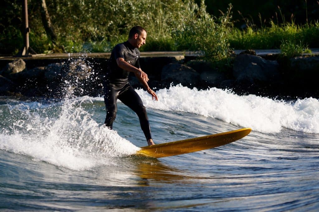 Surfer riding a weird river wave on the Mur in Austria