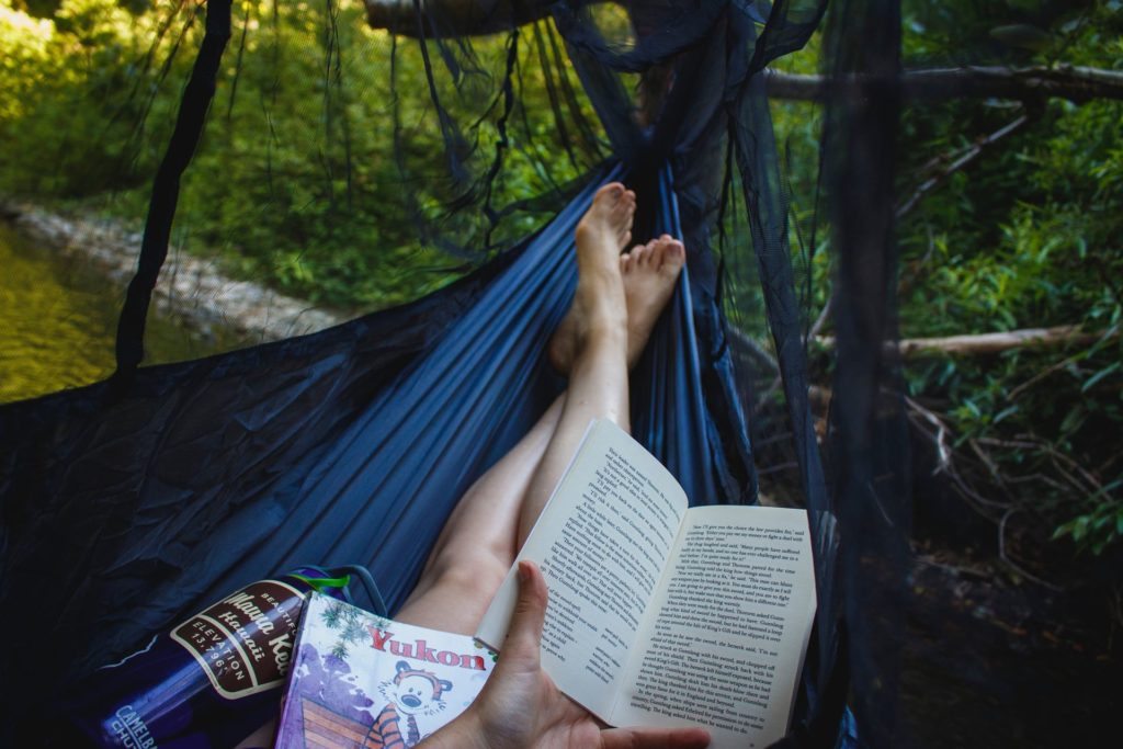 Girl reading a book in a hammock