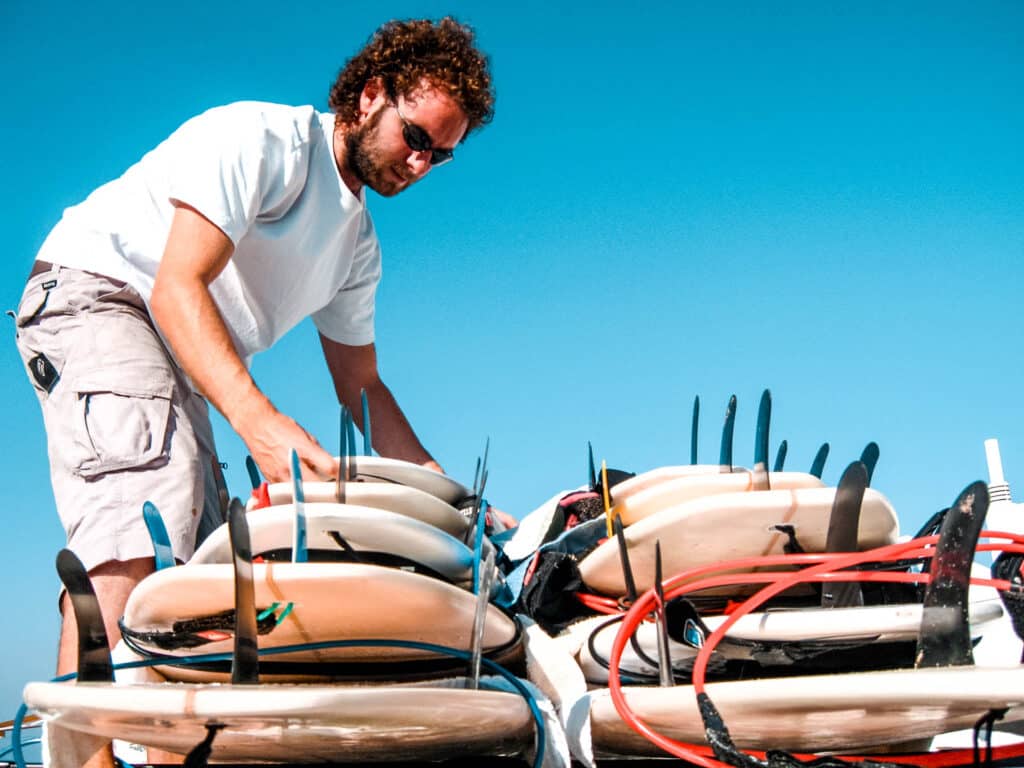 A person arranging surfboards.