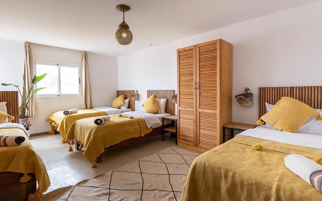 single beds on surfcamp in dorm decorated in earthtones and blue
