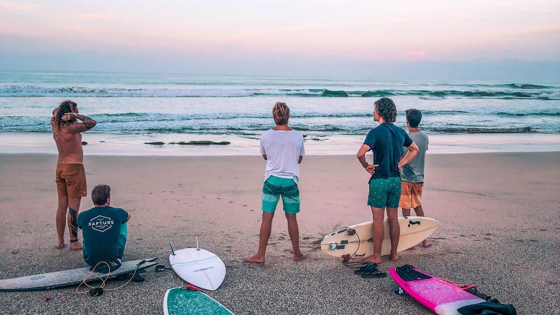 An image of a group of surfers on a beach