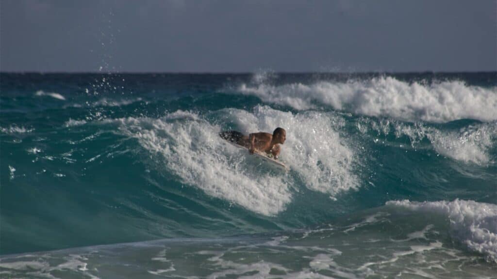 An image of a man bodyboarding on a wave