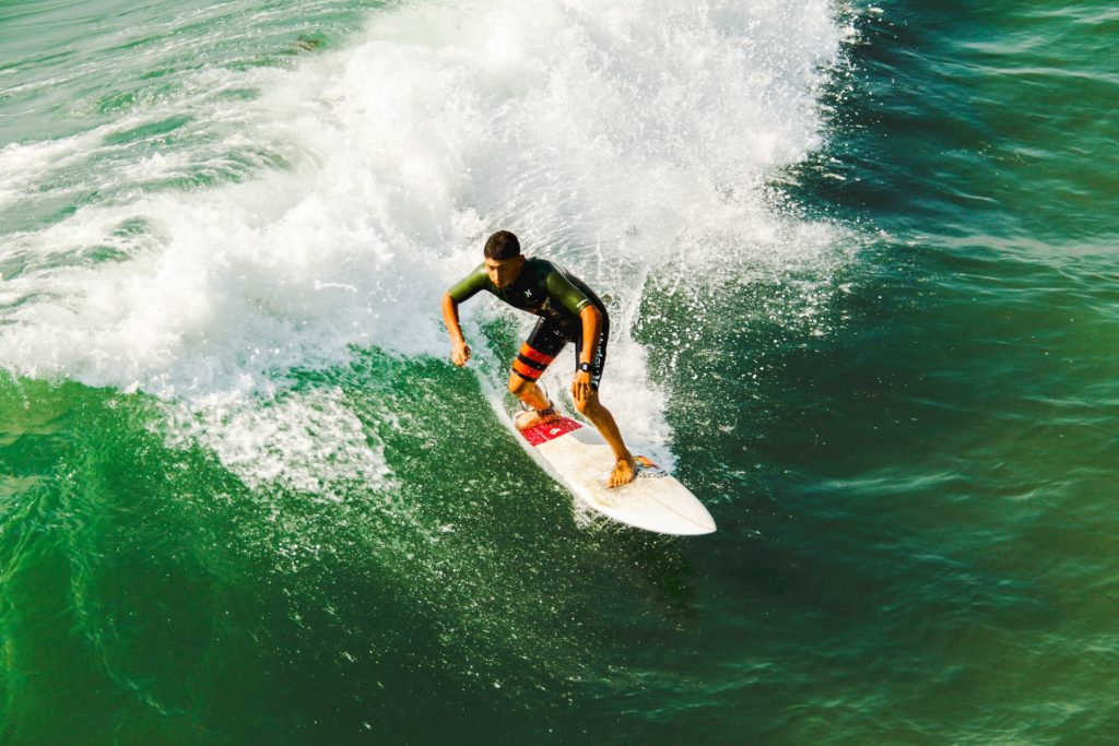 Man riding wave with springsuit on