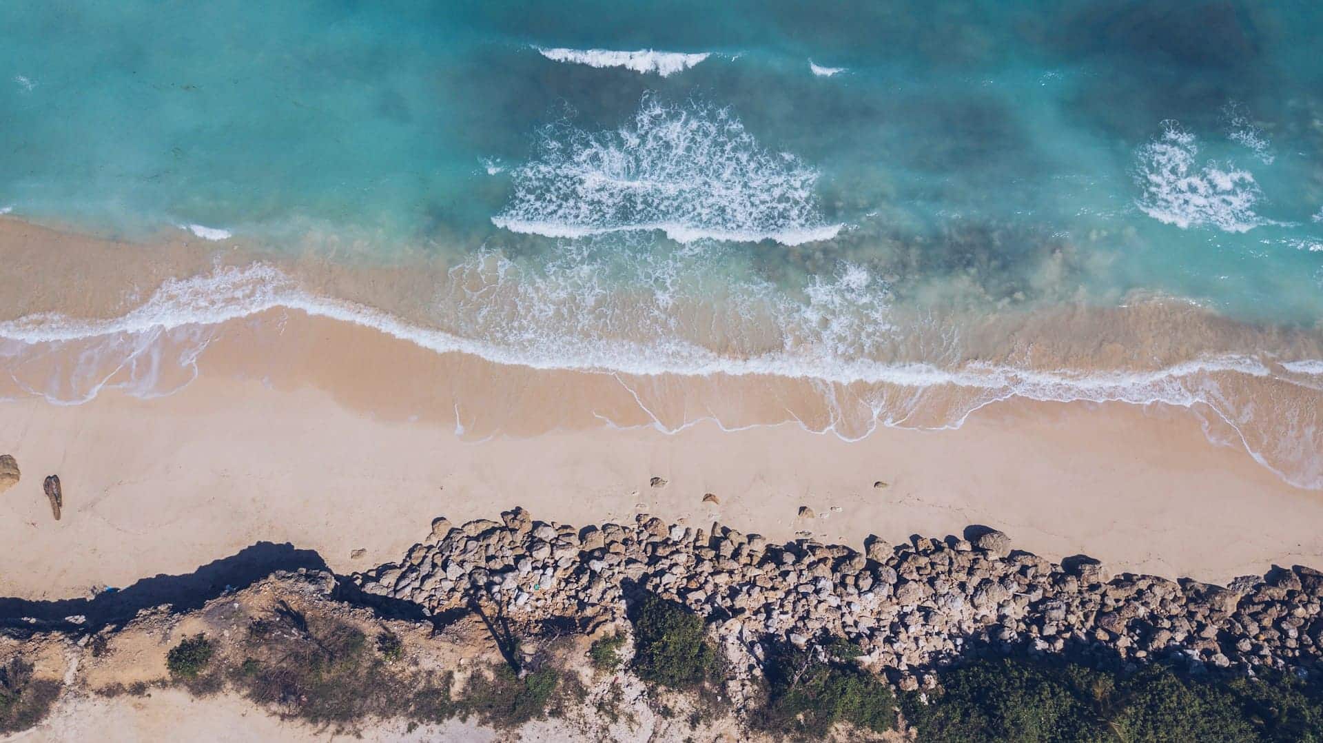 Waves crashing onto the shore of Green Bowl beach in Bali