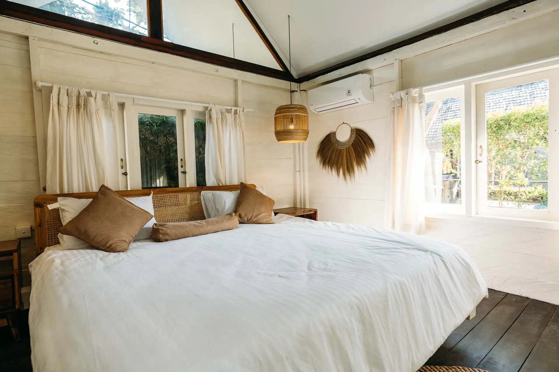 A hotel bedroom decorated in earth tones and white