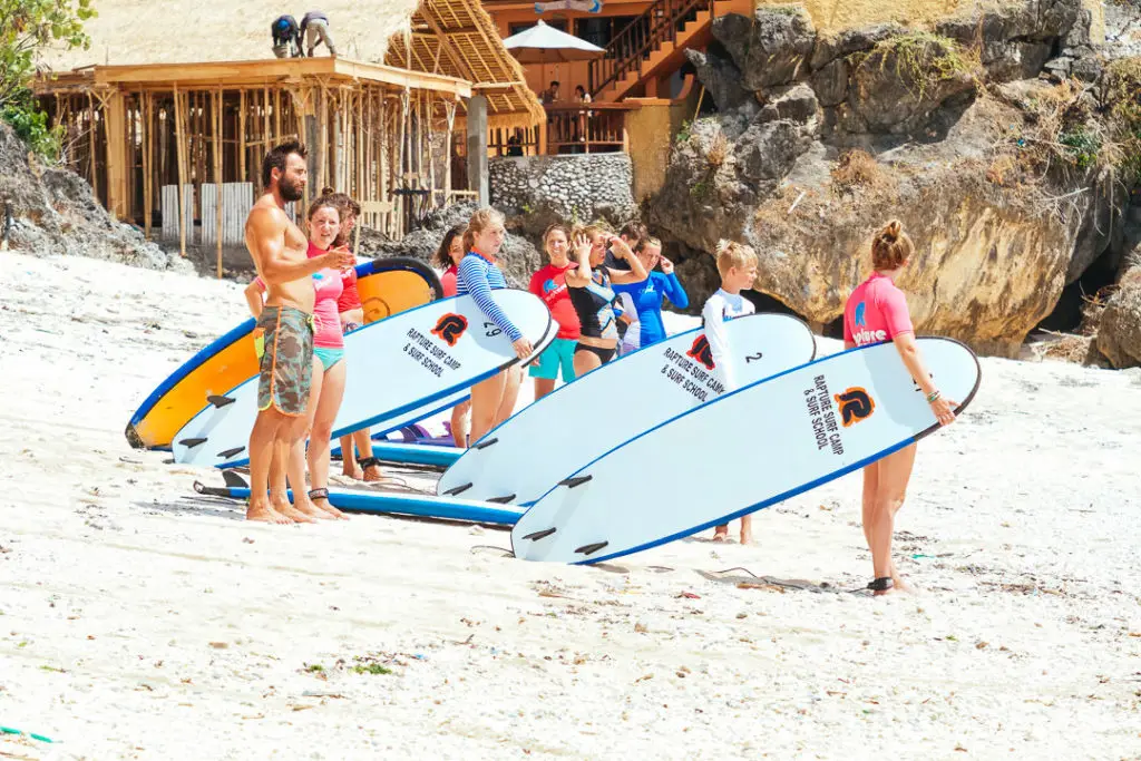 A group of surfers standing up on surfboard