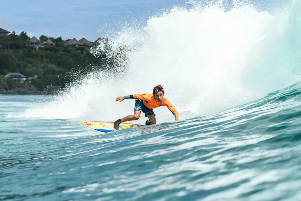 Kid surfing a wave on bali beach
