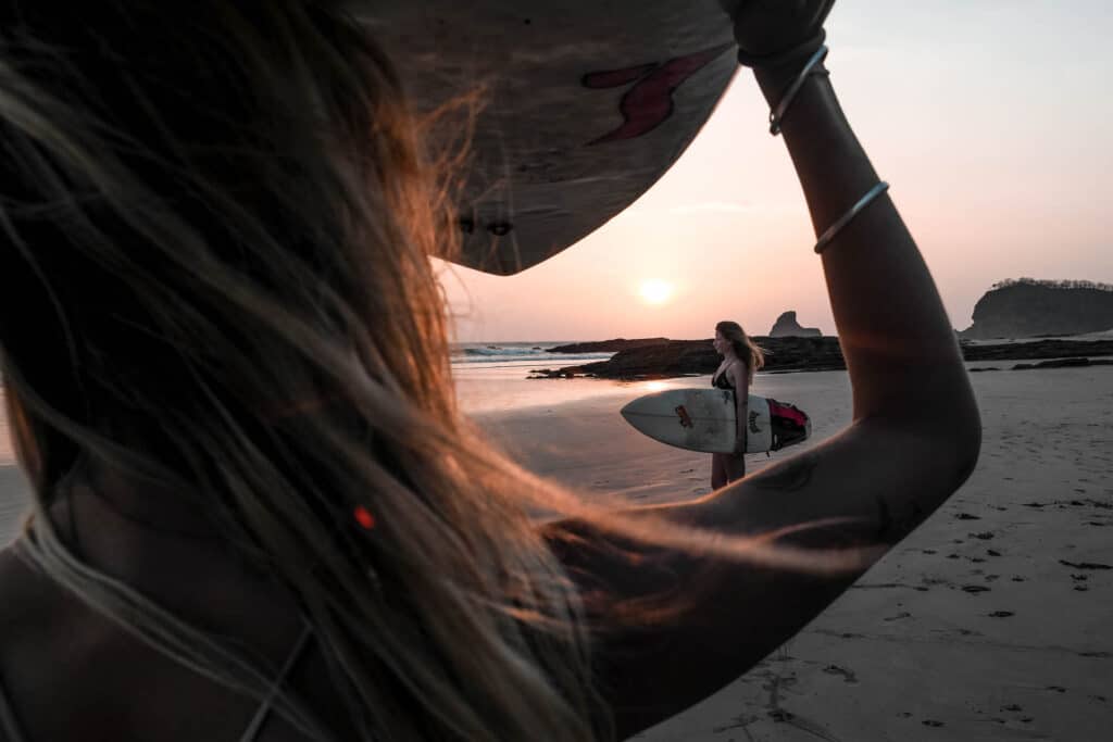 Two girls posing with surfboard at the beach