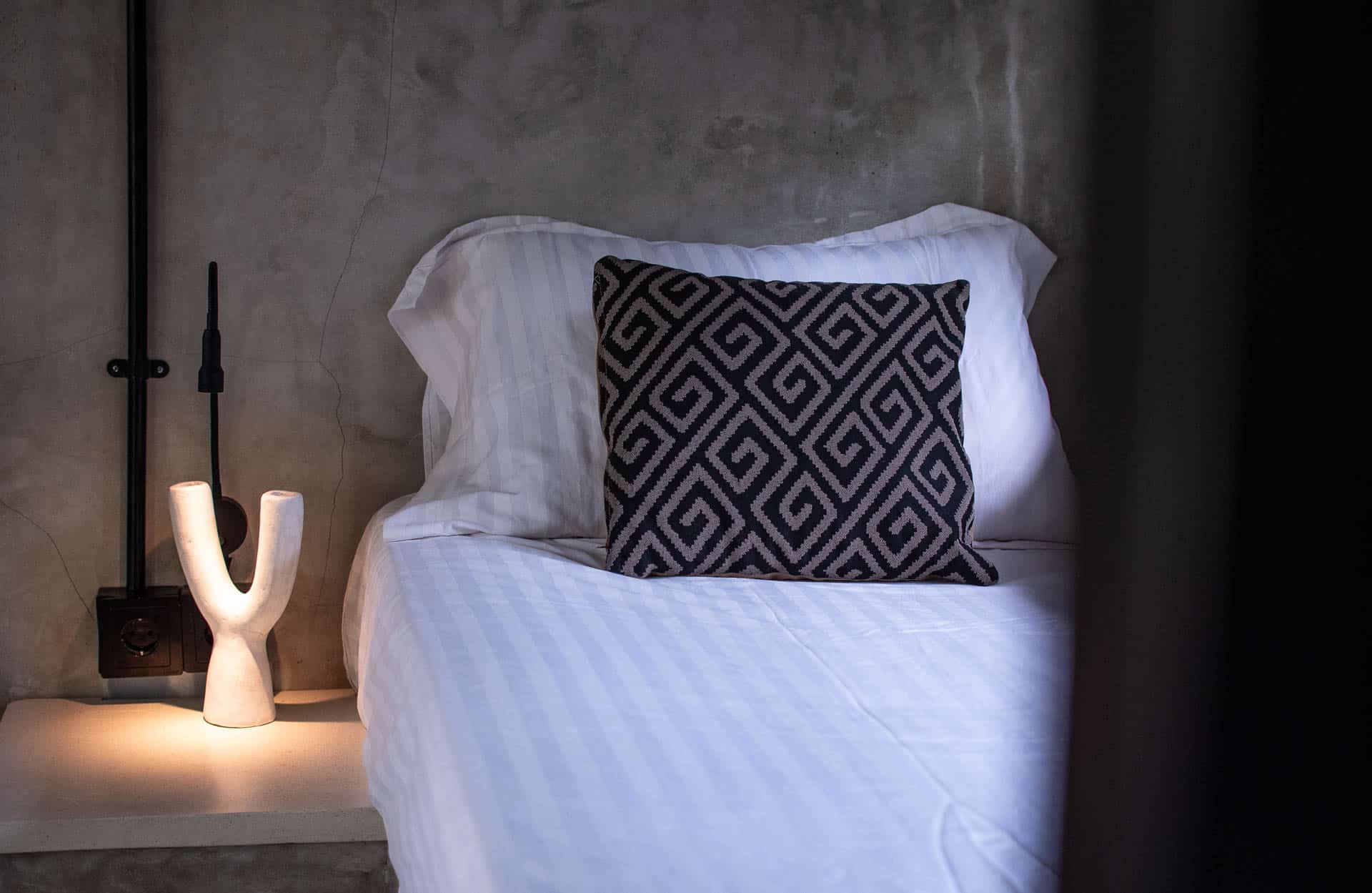 White chair in corner of room with ac in hotel
