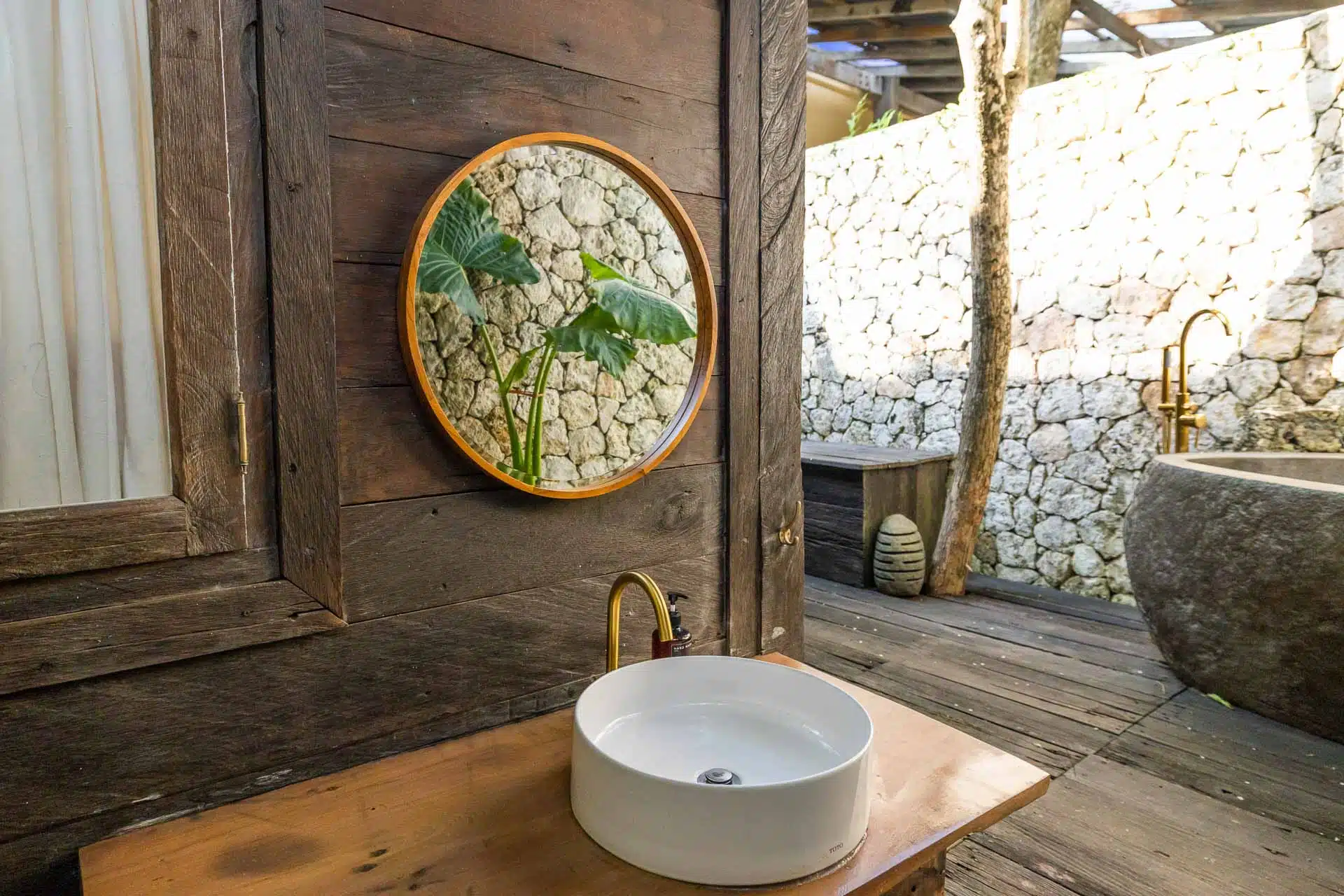 An outside bathroom decorated with earth tones and island vibes