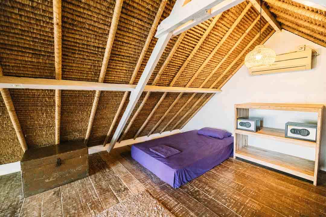 a single bed in our shared twin ac with purple bedding