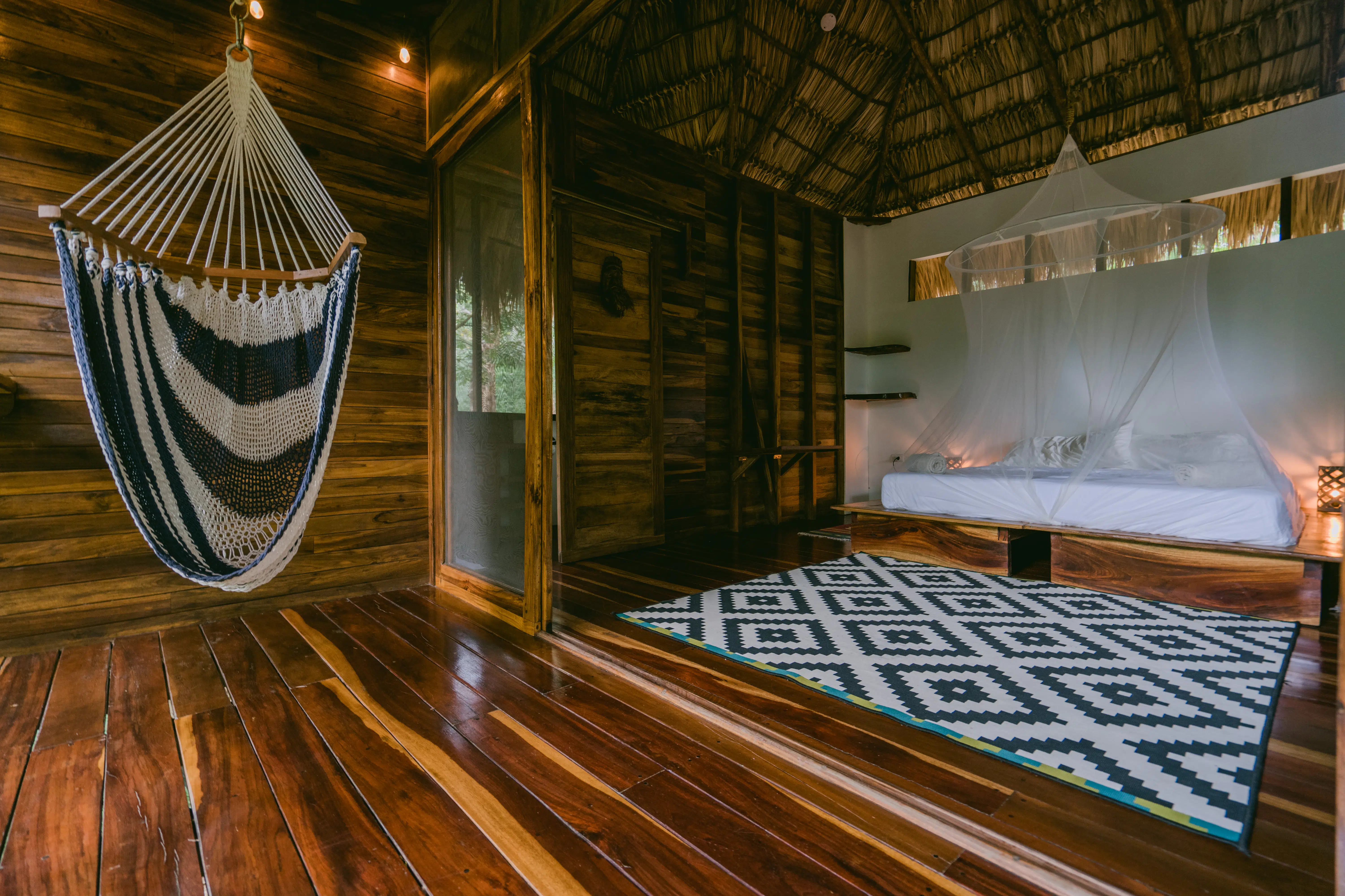 A hammock net chair in a balcony of a spacious an luxurious room