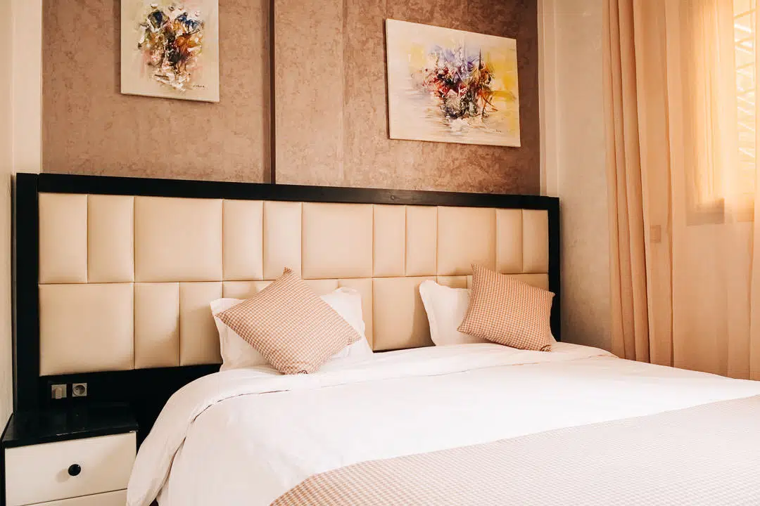 A double bed with pillows decorated in light brown tones
