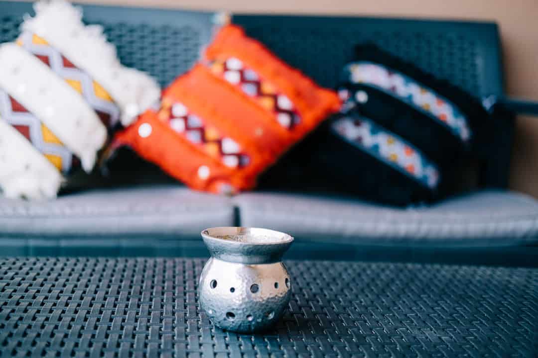 detail of morrocan ashtray in table with pillows behind