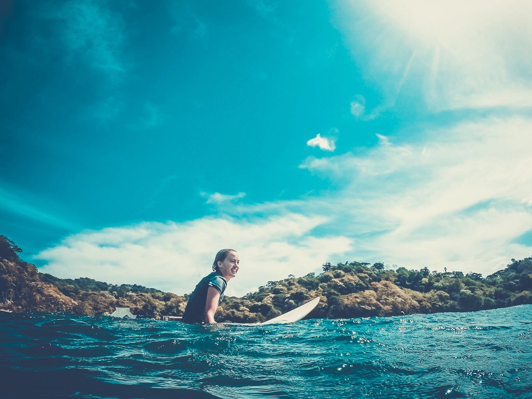 Happy surfer girl waiting for swell