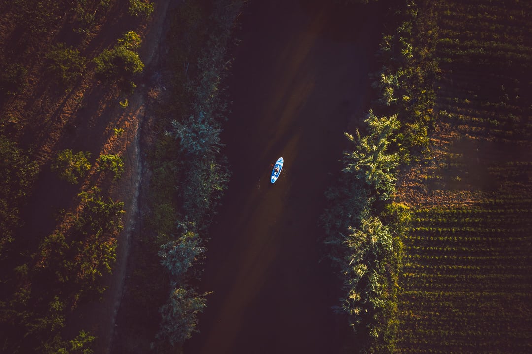 Aerial view of a surfer paddleing on the river