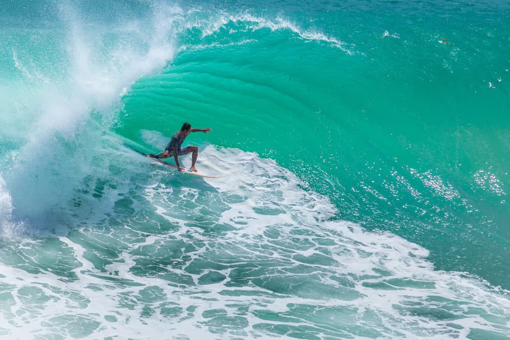 Ein Profi-Surfer auf einer Welle in Seminyak