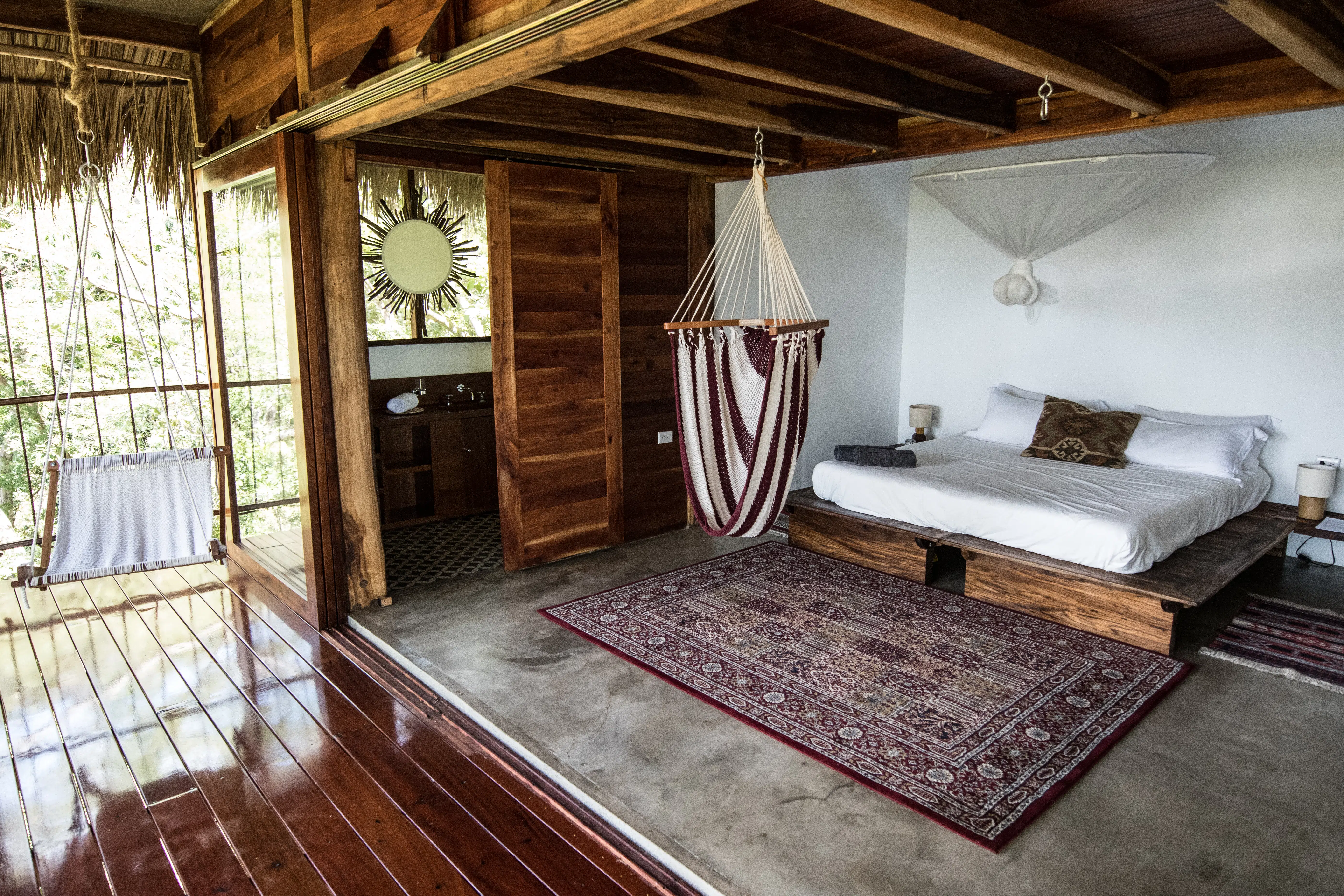 an open spaced room with a bed and hammock chair