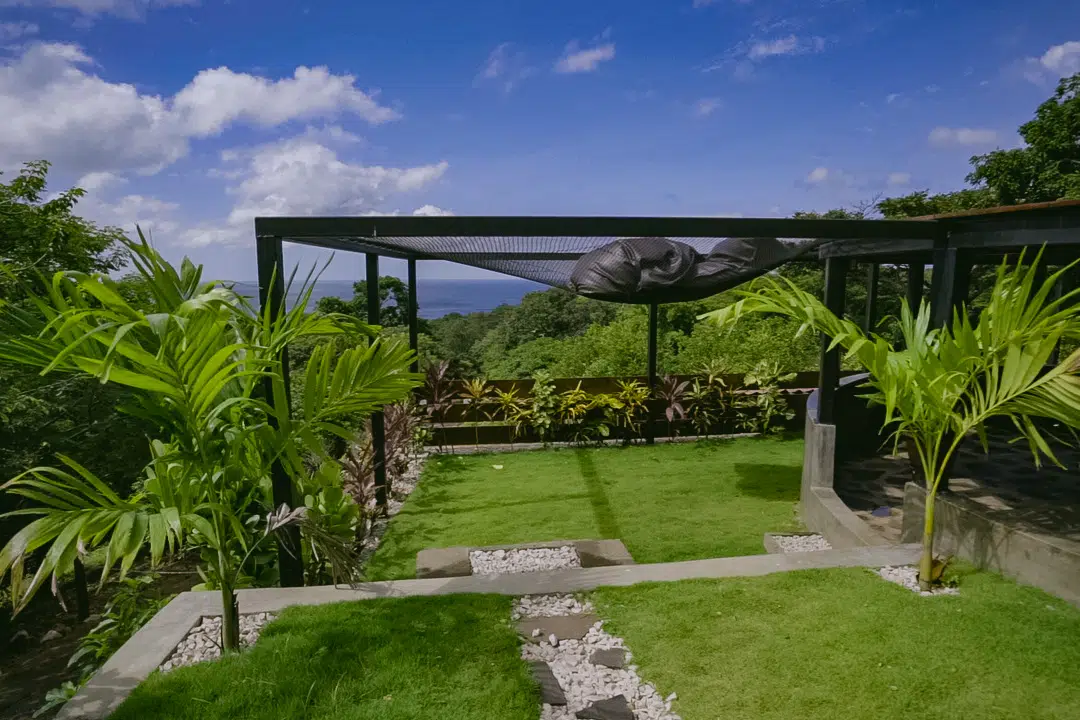 A garden with grass and trees overlooking the ocean