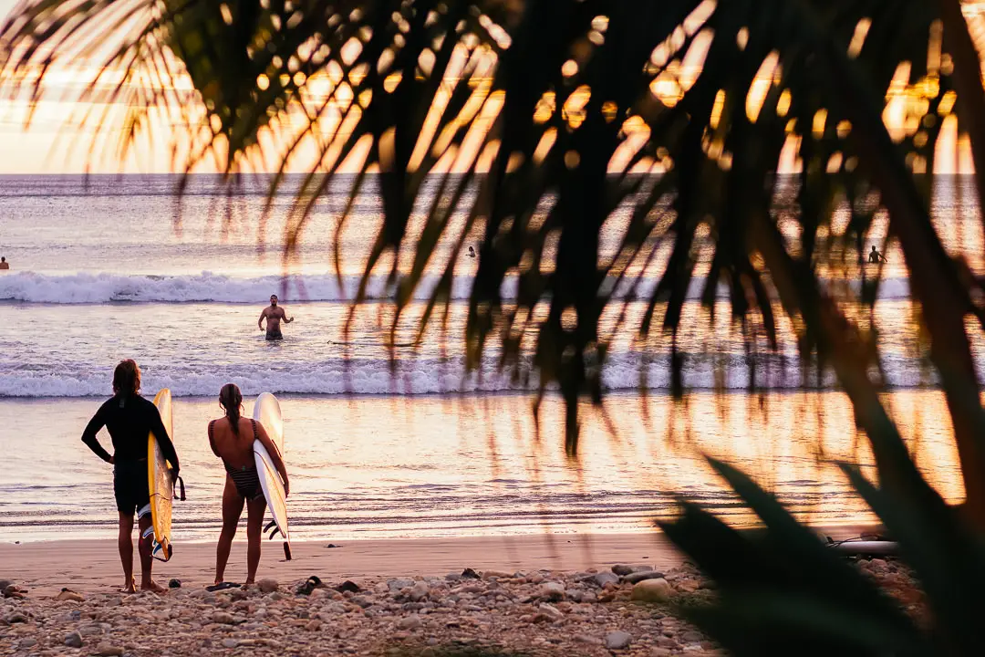 Surfers with boards looking over horizon