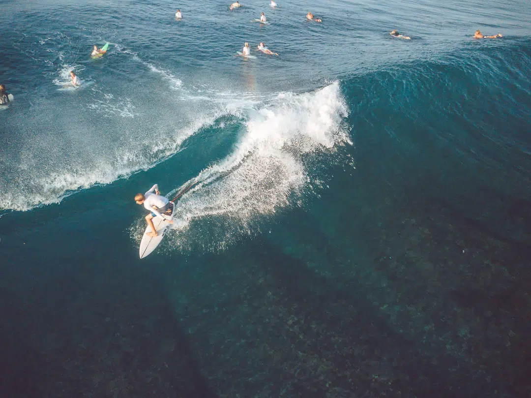 A group of surfers in the water riding waves in padang