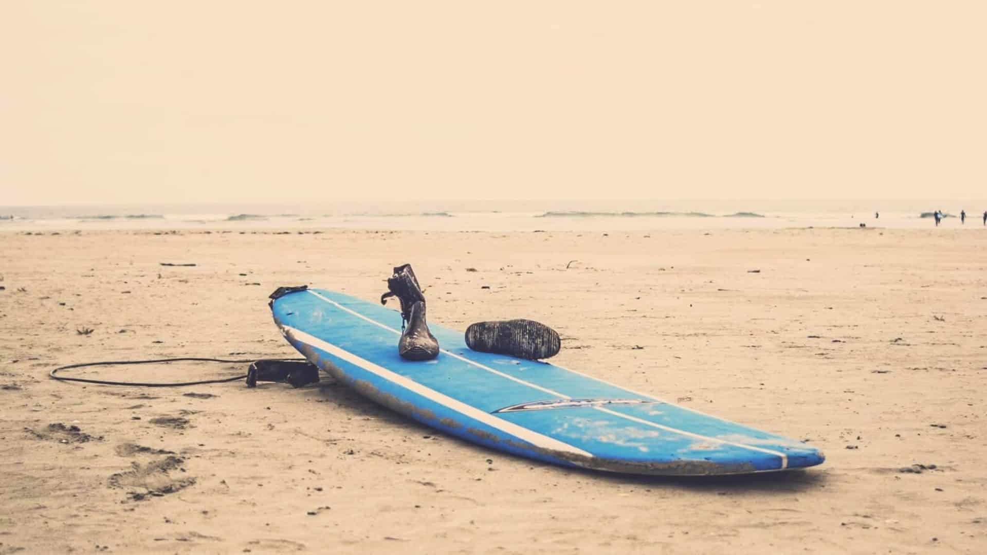 An image of a surfboard and surf shoes