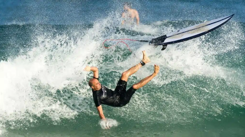 An image of a surfer being injured after falling off of a surfboard