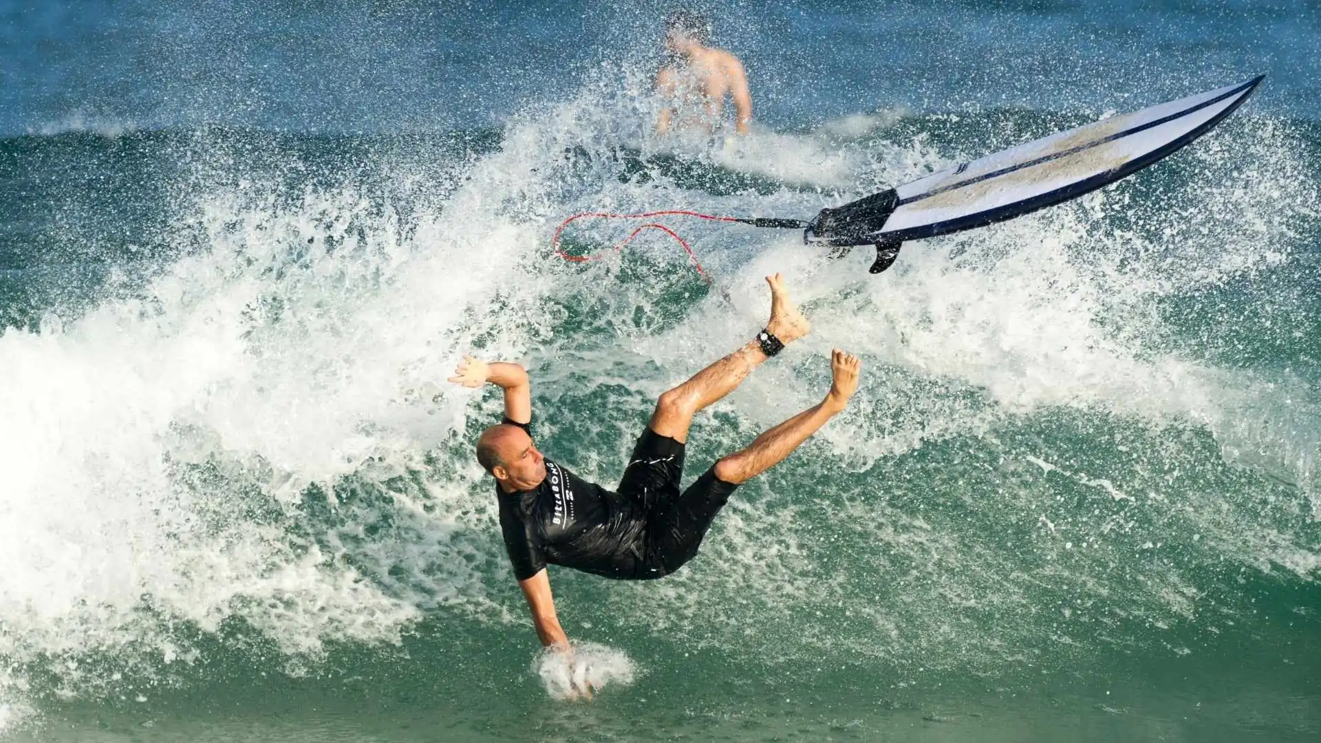 An image of a surfer being injured after falling off of a surfboard