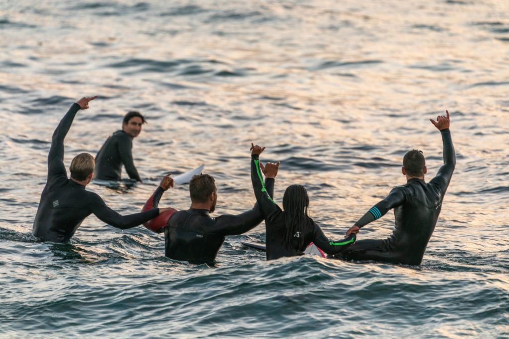Surfers linking hands in the water