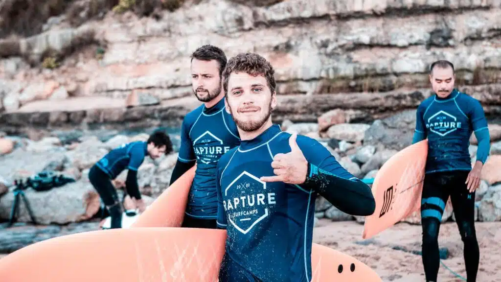 An image of surfers in Portugal by a cliff side