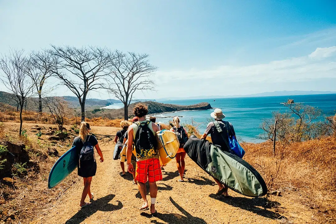 A group of surfers arriving at the beach for lessons