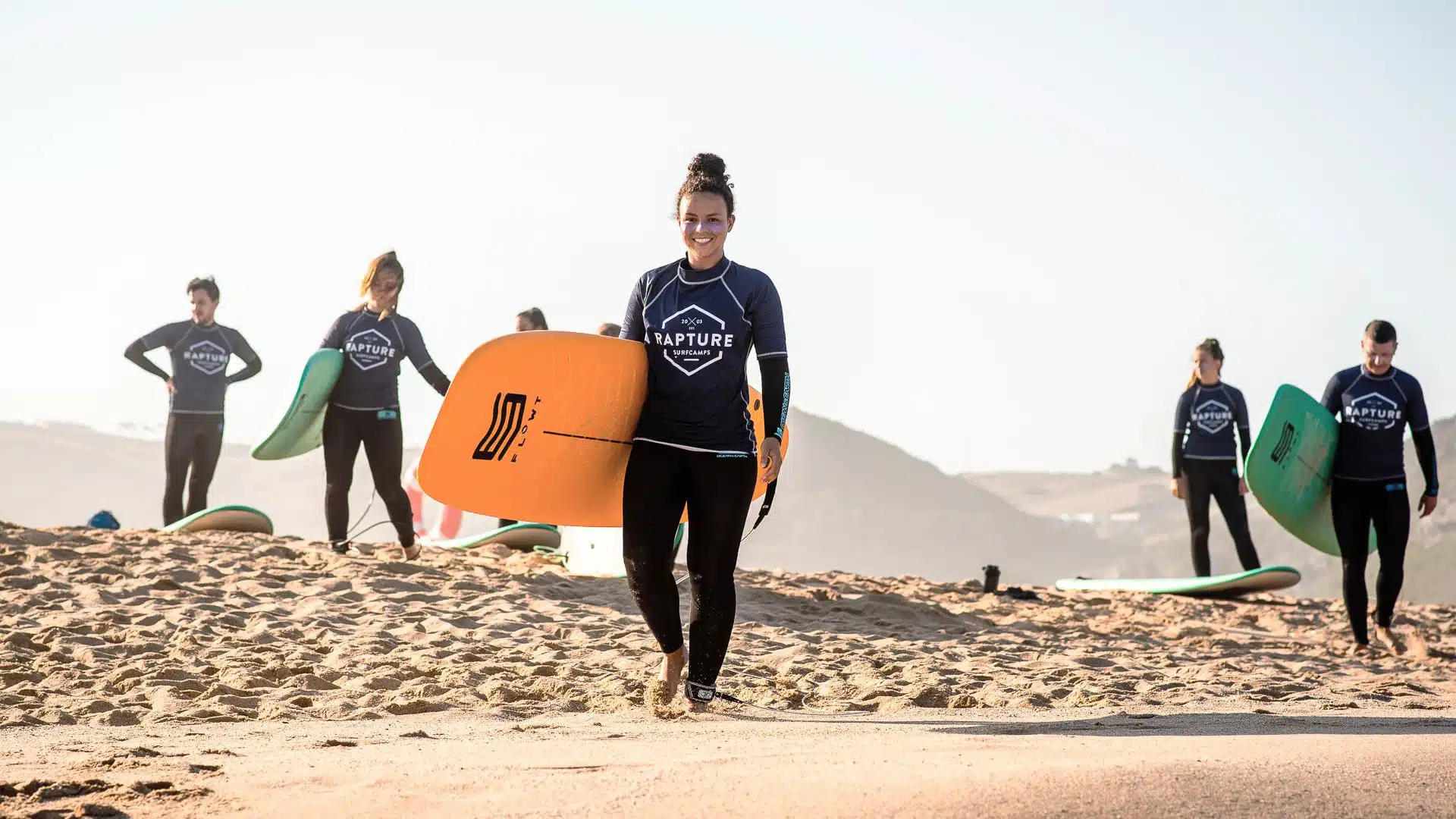 An image of Rapture surfcamp guests on the beach in Ericeria