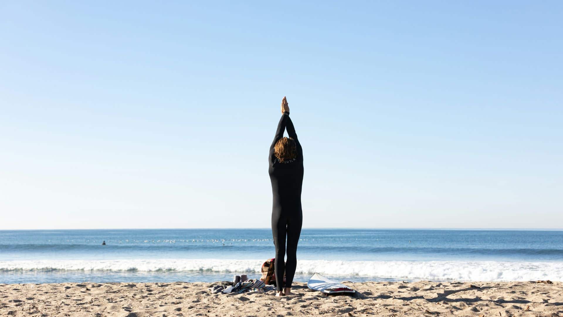 An image of a surfer stretching before a surf