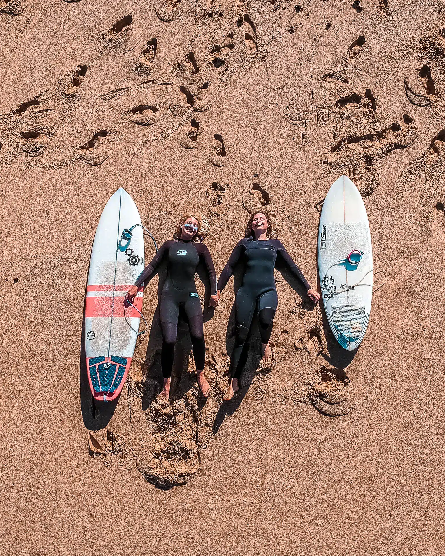 4 people carrying surf boards to the beach