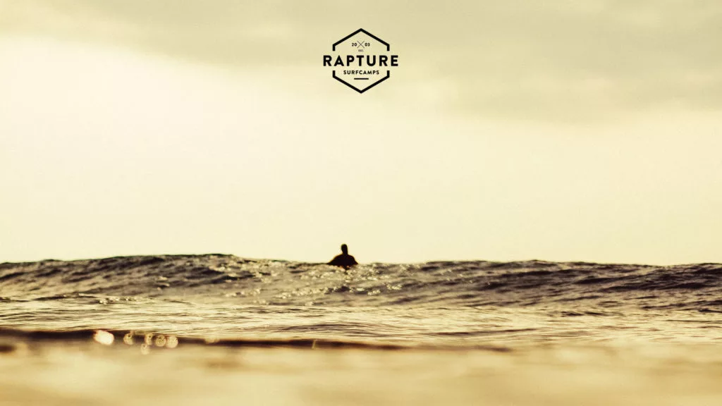 A surfer waiting for wave at sunset