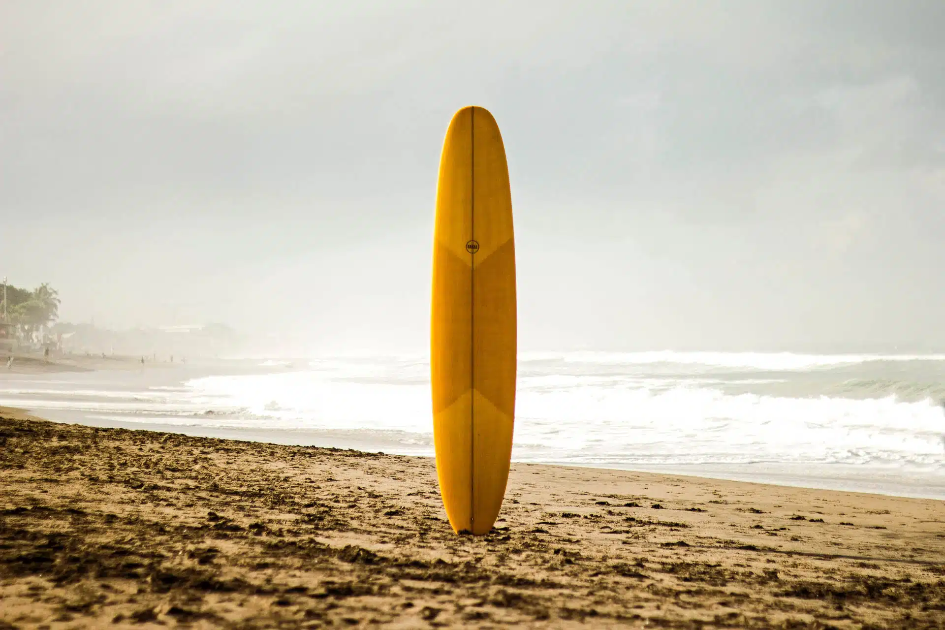 Yellow Surfboard on an Empty Beach