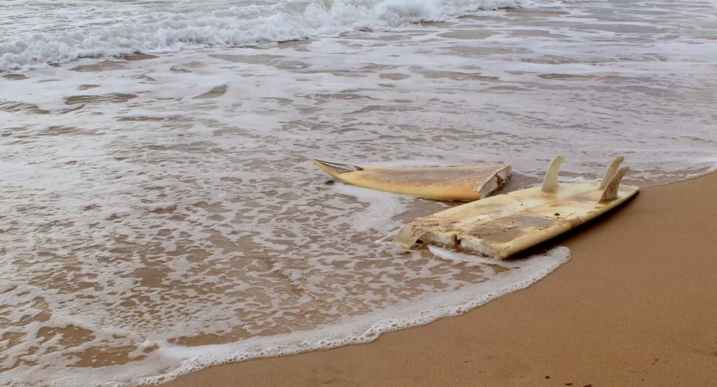 Broken surfboard on the beach